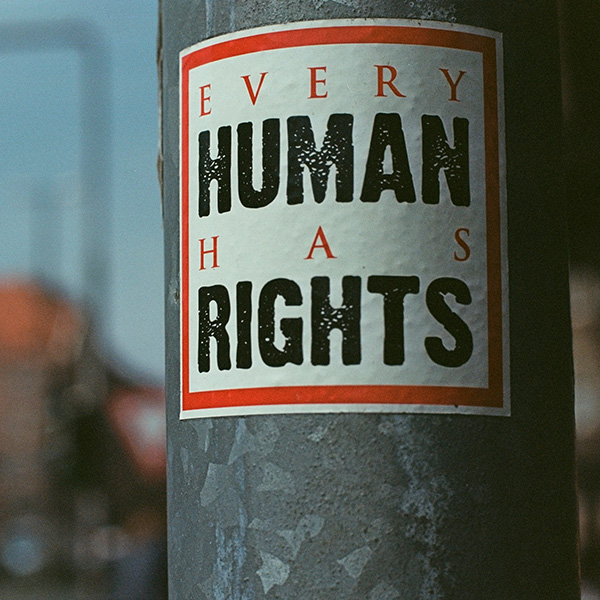 A poster on a light pole that says 'Every Human Has Rights".