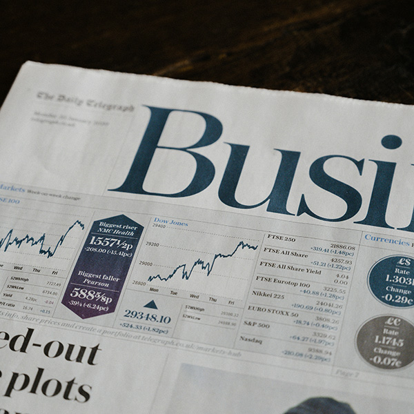 News paper highlighting business topics and graphs.
