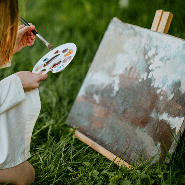 A person painting outdoors