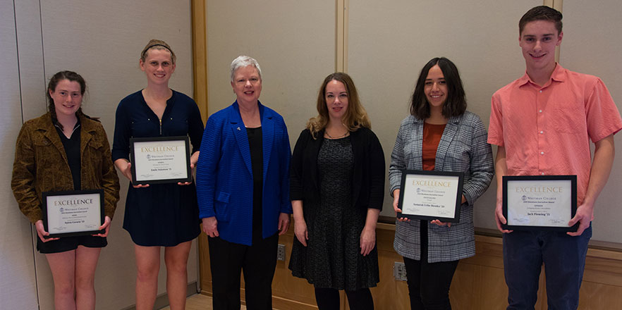 Four students stand with President Kathleen Murray and writer Sarah Kendzior with their award plaques.
