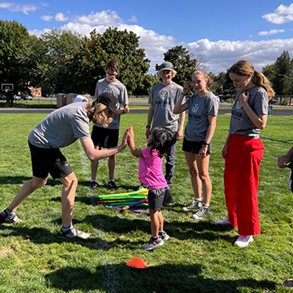 Whitman College Cross Country team members working with elementary students