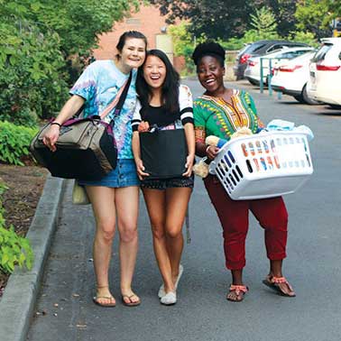 Three students smiling during move in at Whitman College