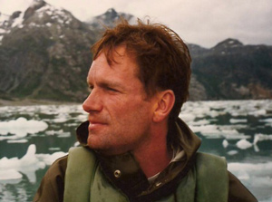David Nord, standing outdoors with mountains and icy waters in background