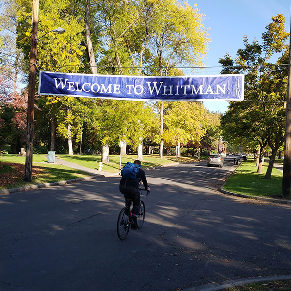 Welcome to Whitman College banner with bicyclist riding underneath