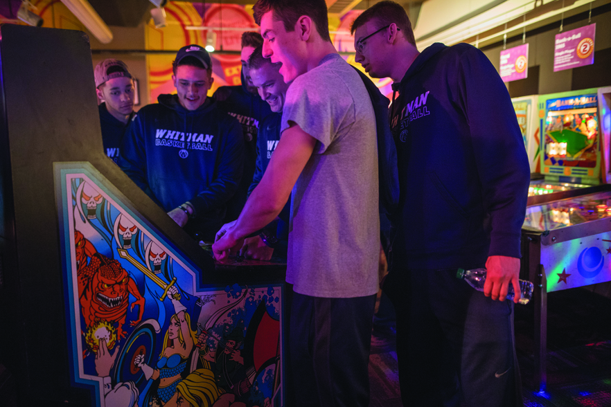 The men’s team tries a different ball game at the Roanoke Pinball Museum during their trip to Virginia.  Left to right: Austin Butler ’19, a wing player and psychology major; Jacobs-Jones; forward Ben Beatie ’19, a rhetoric studies major; Head Coach Eric Bridgeland; wing player Jack Stewart ’19; and forward Andrew Harvey ’20. 