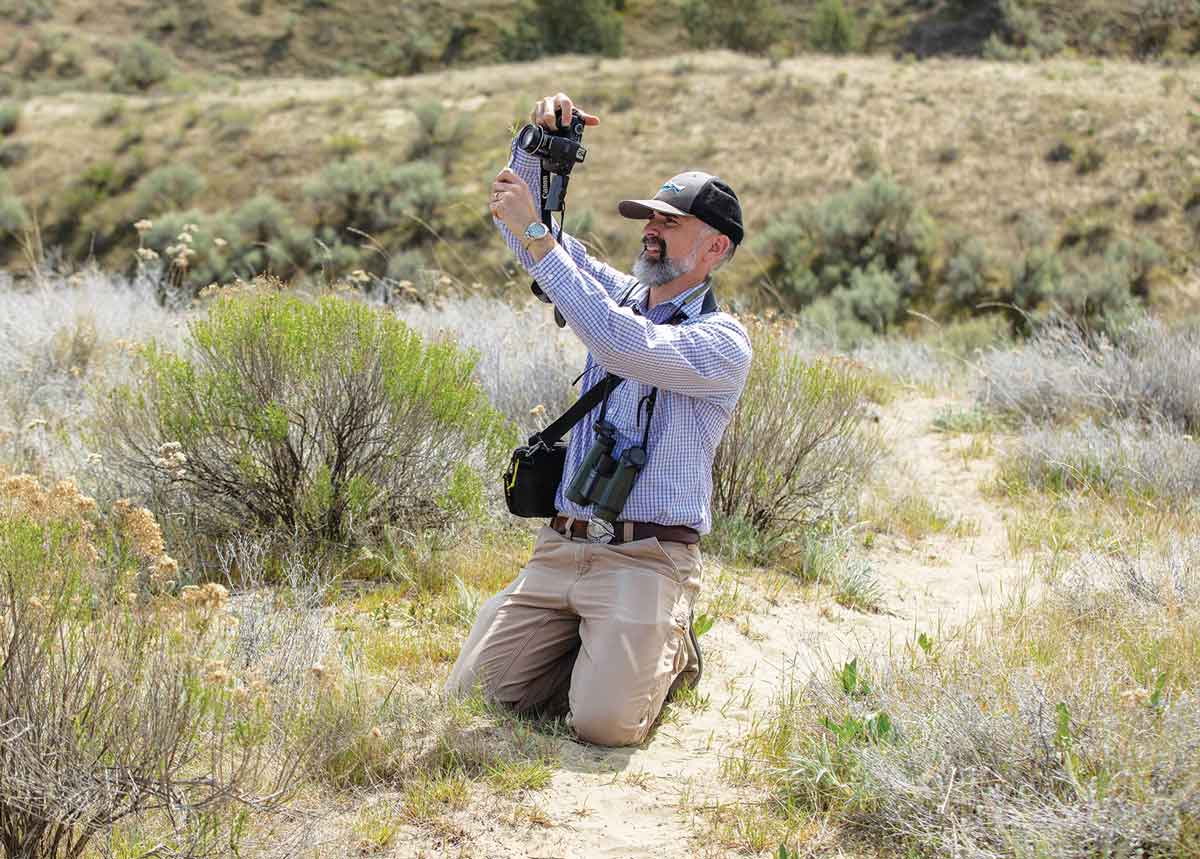 Tim Parker taking pictures in a field