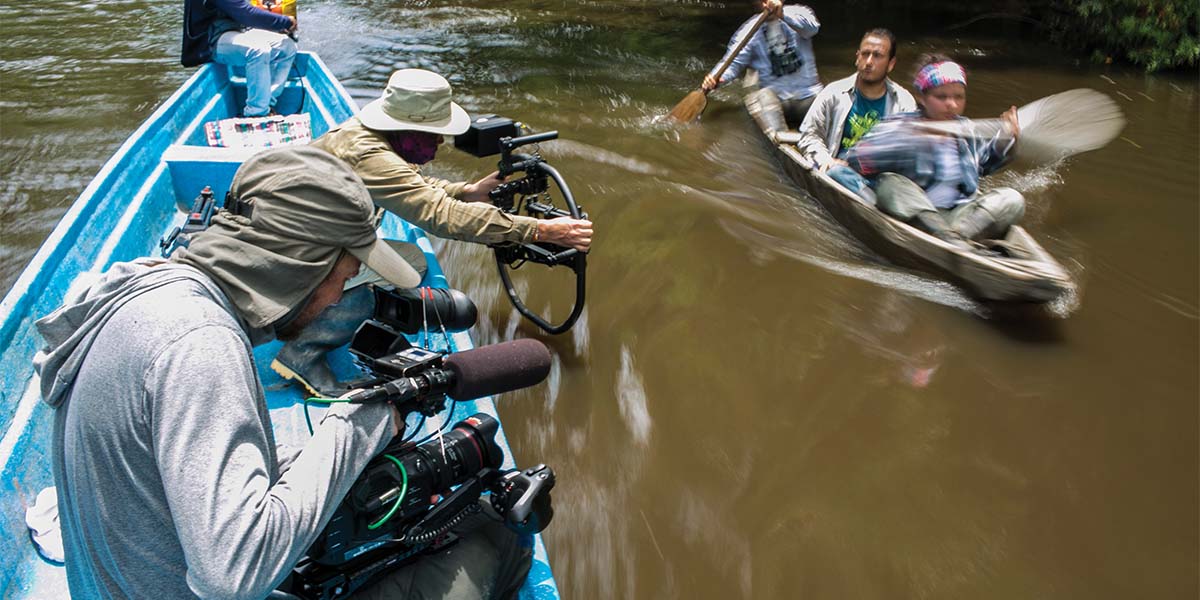 Rick Smith films primate researchers on a river.