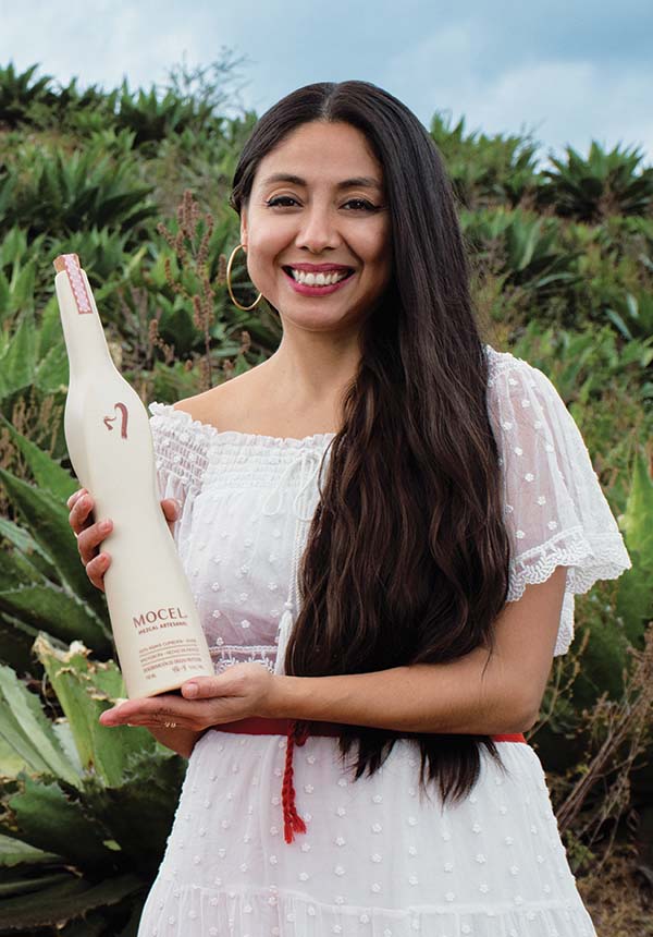 Rosalinda Mendoza holding a bottle of mezcal.