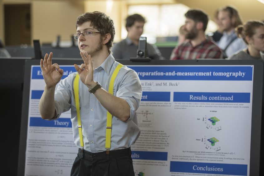 Physics major Aidan McCormick '17 in front of his poster on quantum state tomography, or the process of characterizing a quantum optical system.