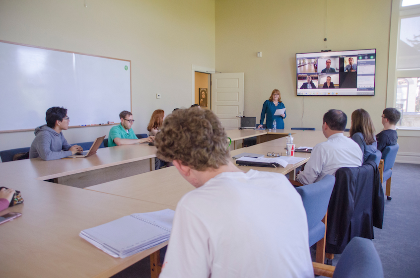 Whitman students learn about banking and finance opportunities in a video conference with alumni, as Kimberly Rolfe (standing), director for business engagement at Whitman, moderates.