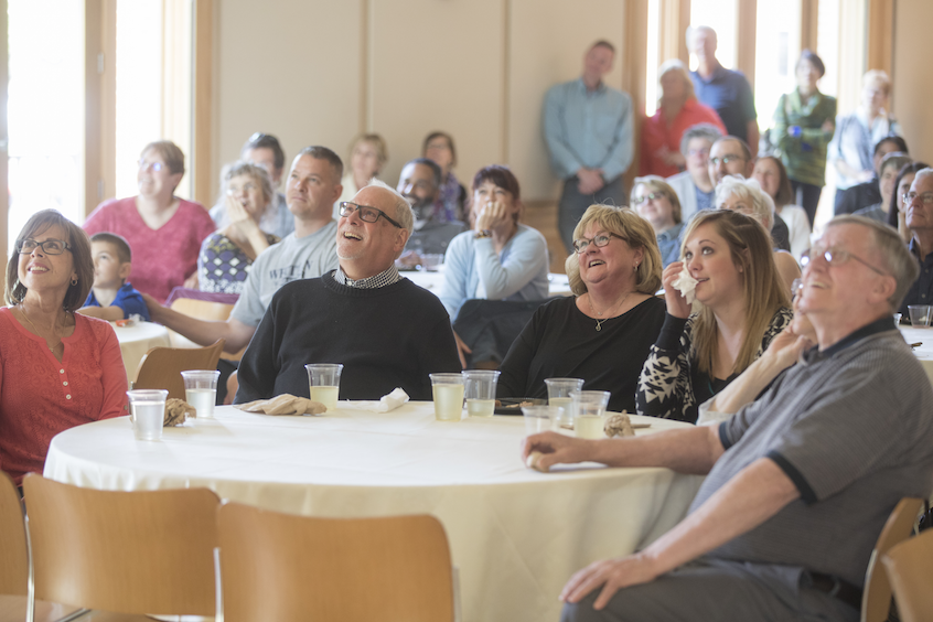 Cleveland, Sorenson (center right) and their daughter, Molly (with napkin), enjoy a video tribute to him by Tywen Kelly '18, a film and media studies major.
