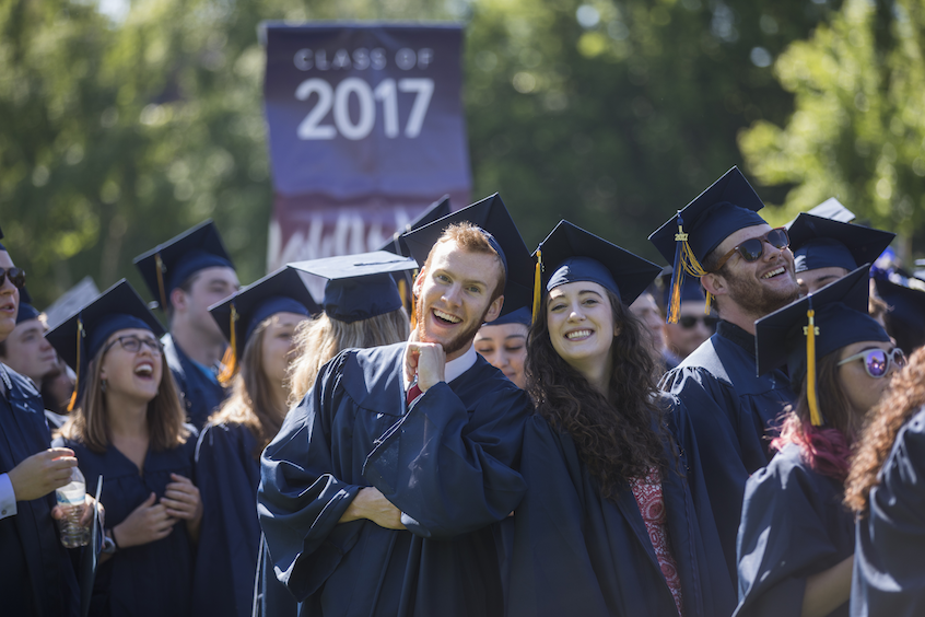 Economics and psychology major Spencer Mueller '17 (center left) poses with classmates at Commencement.