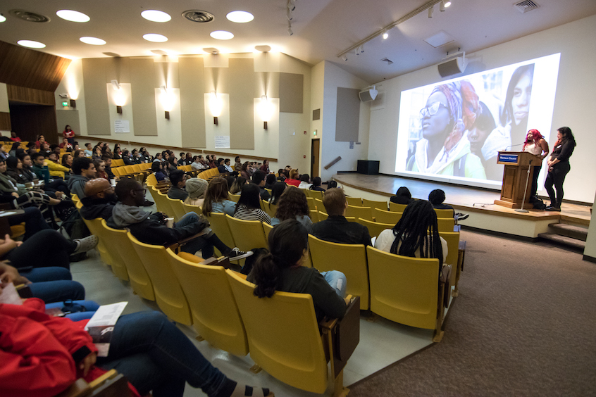 Keynote speakers Alisha Agard ’15 (left at podium) and Ashley Hansack ’15 (right at podium) summarize what they did at Whitman to challenge underrepresentation. Examples include creating “The Inside Scoop,” a guide to college for first-year students, and “International Workers Day” to bring awareness about laborers many people take for granted. 