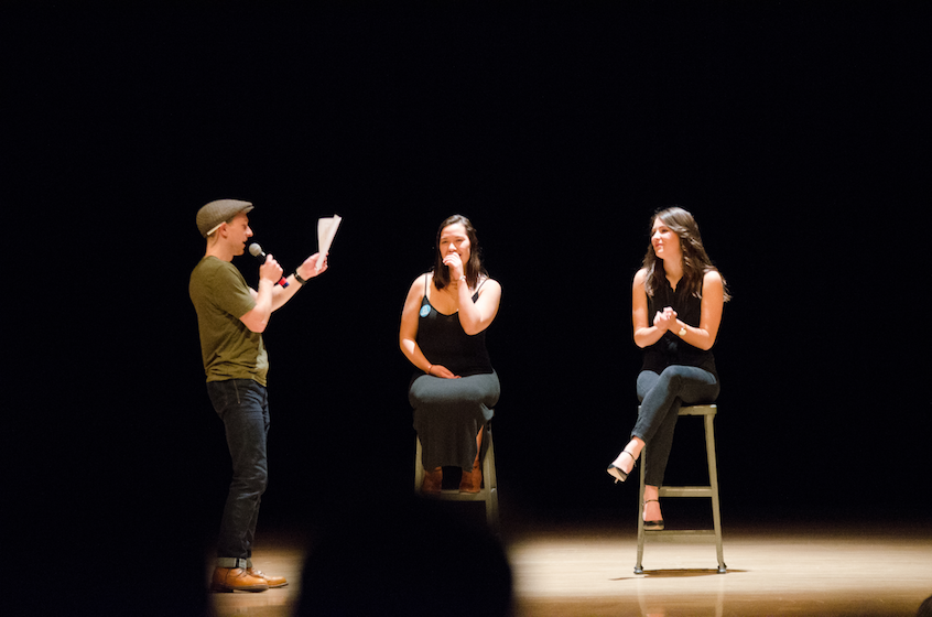 Contestant Ethan Gladhill '19, a biochemistry, biophysics and molecular biology major and member of Sigma Chi, recites a poem he wrote for organizers Mariah Ng ’19 (center), a psychology major, and interdisciplinary major Mikaela Slade '19. 