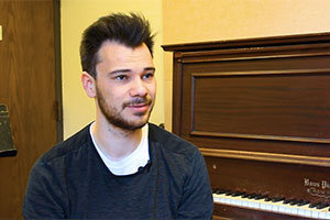 A portrait of student Lukas Koester sitting at the piano.