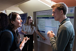 Owen Crabtree (‘19 Psych, Right) and Kari Hampson (‘19 Psych, Middle/Back) engage with other students during the 2019 Undergraduate Conference.