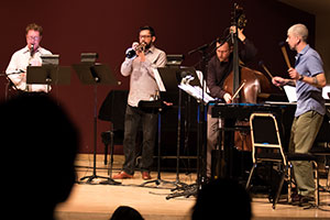 Four musicians play on a stage.