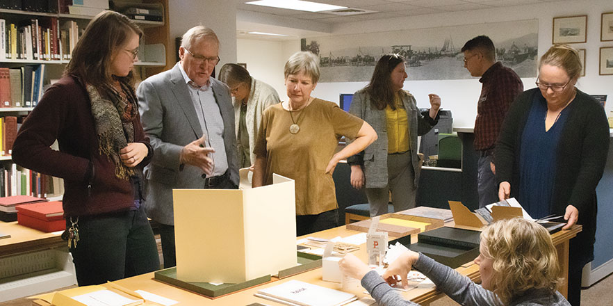 Peter Newland ’67, center, and his wife, Robyn Johnson, right, talk with Antonia Keithahn, assistant director of Disability Support Services, about their donation of artists’ books during an open house in the Penrose Library.