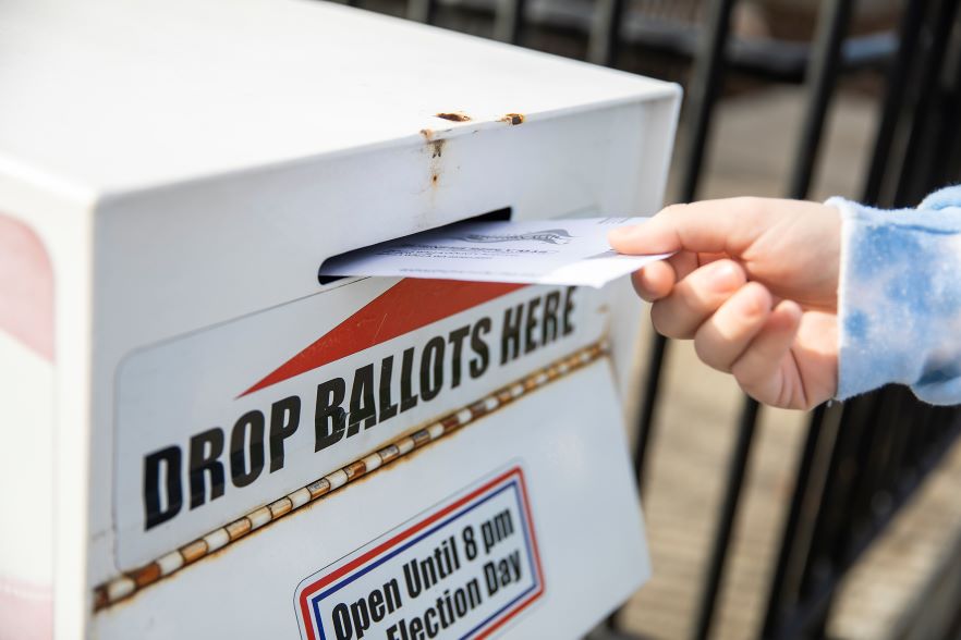 A ballot is inserted into an official drop box in Walla Walla
