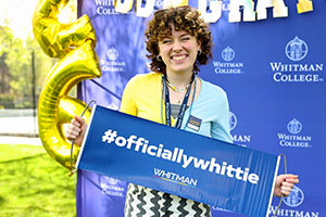 Incoming student smiling with a Whitman sign.