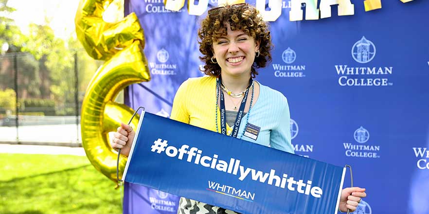 Incoming student, Anna-Gutrich, smiling with a Whitman sign.