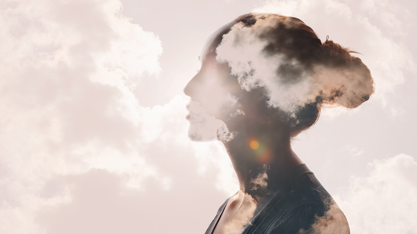 Abstract image of clouds superimposed over the silhouette of a woman.