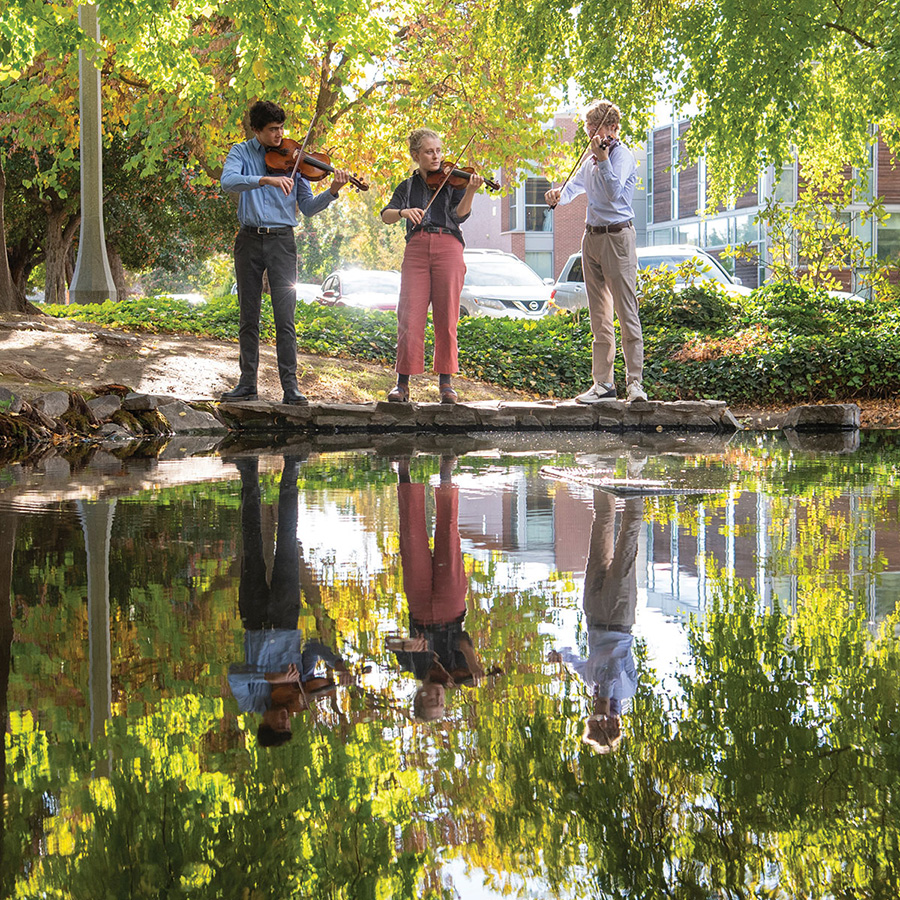 students playing music by college creek