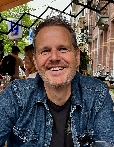 Portrait of Jason Pribilsky, sitting in an outdoor cafe.