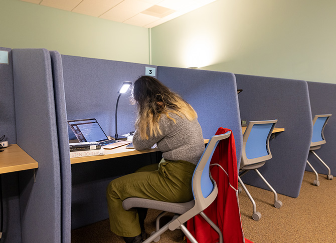 Student in the ARC using the divided desk area to focus on their work.