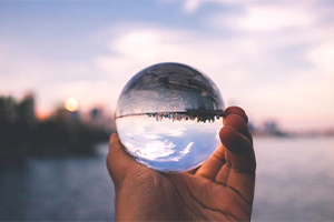 Looking at a city through a glass sphere held in a hand.