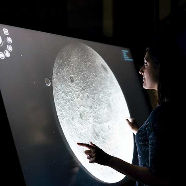 Person looking at a screen displaying the moon.