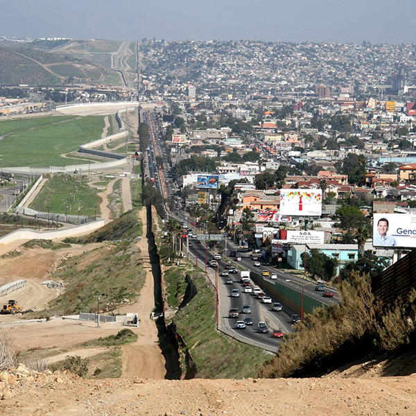 A long wall creating a border between two pieces of land.