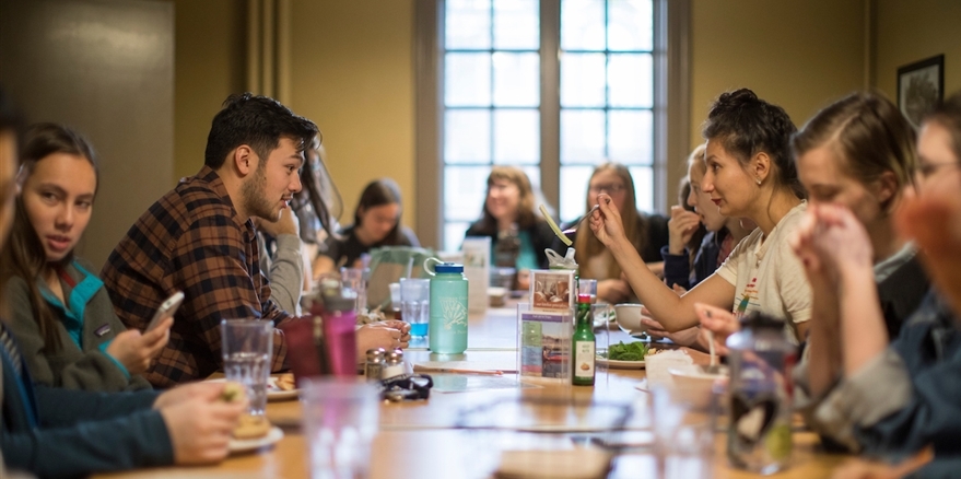 Students and the native speaker conversing at a French table session