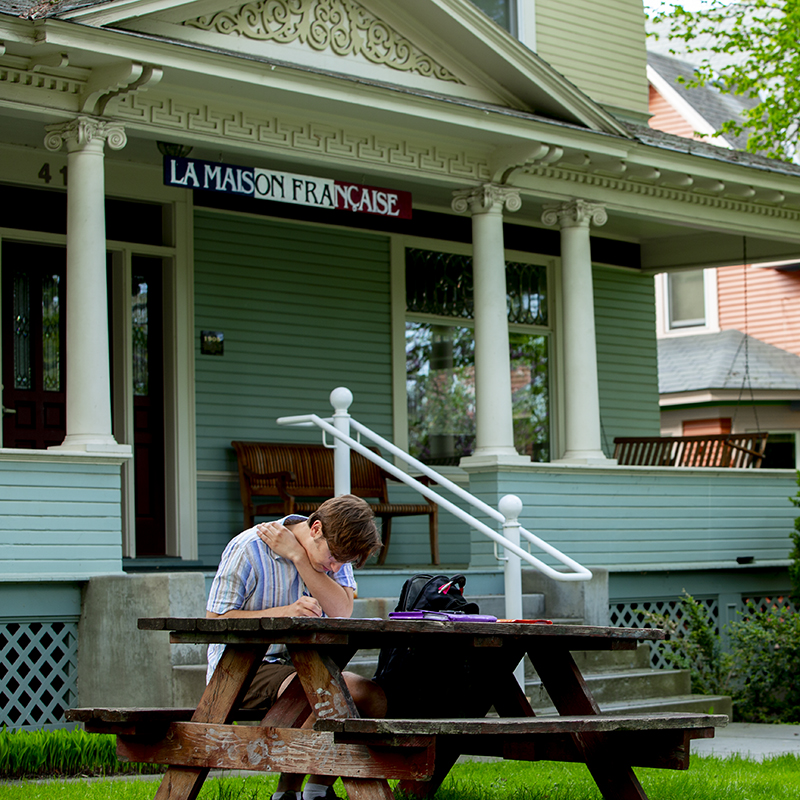 Student outside the French house on campus.