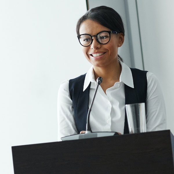 Person smiling behind a podium.