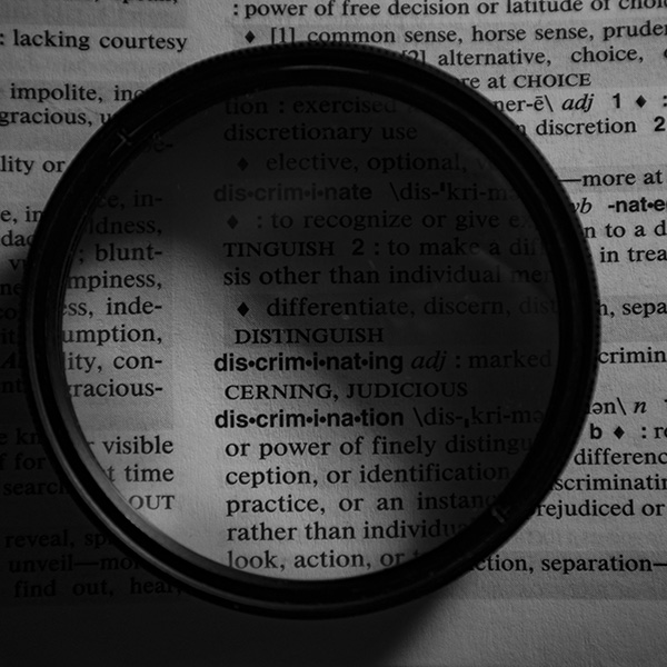 A lense focused on the words discriminating and discrimination.