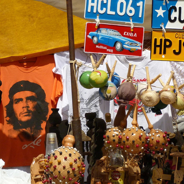 A stand with cuban license plates, musical instruments, and t-shirts. One of the shirts displaying Che Guevara's image.