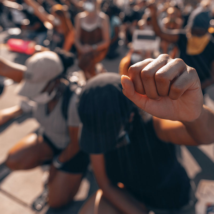 Fist raised in awareness from people at a gathering.