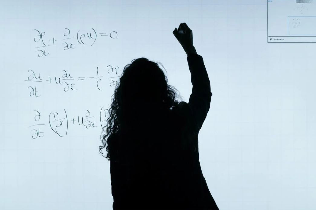 Professor writing on a dry-erase board.