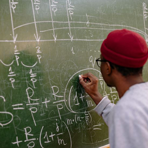 Student writing on a chalkboard.