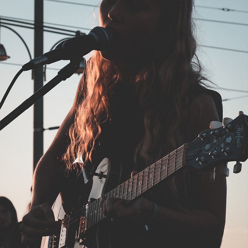 Singer outdoors performing with a guitar