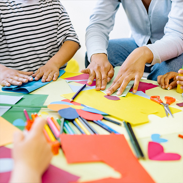 Multiple hands working on a project together.