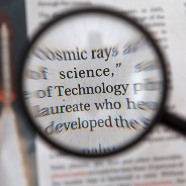 Magnifying glass focused on the word "science" on a printed sheet.