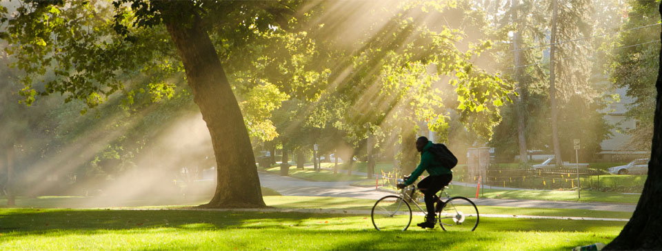 student riding a bike on campus