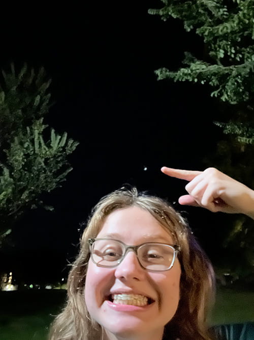 Pam pointing upwards at the night sky.