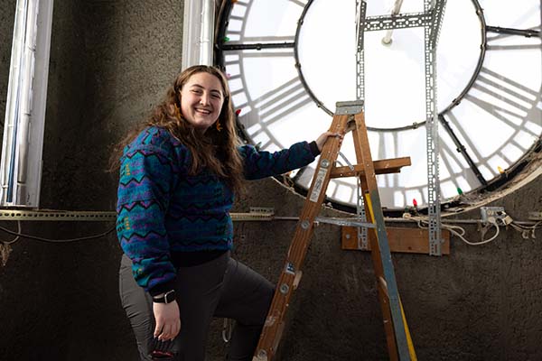 Zoe Perkins near a ladder inside the clock tower.