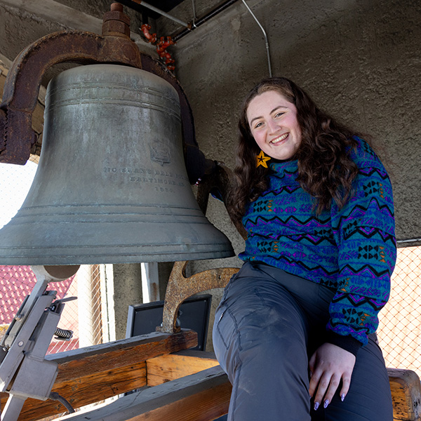 Zoe Perkins huggging the clock bell.