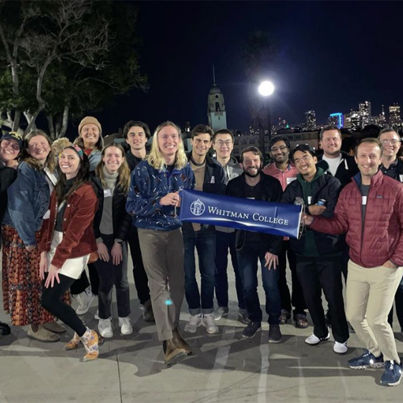 Alumni group outdoors at night.