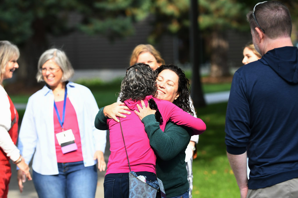 Whitman College Alumni embracing each other in a hug. 