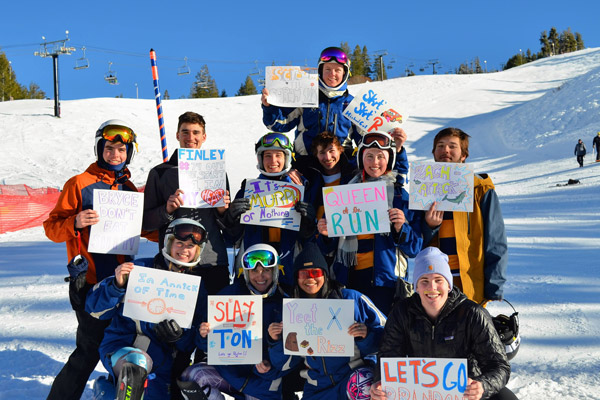 Ski team huddled together, snowy background